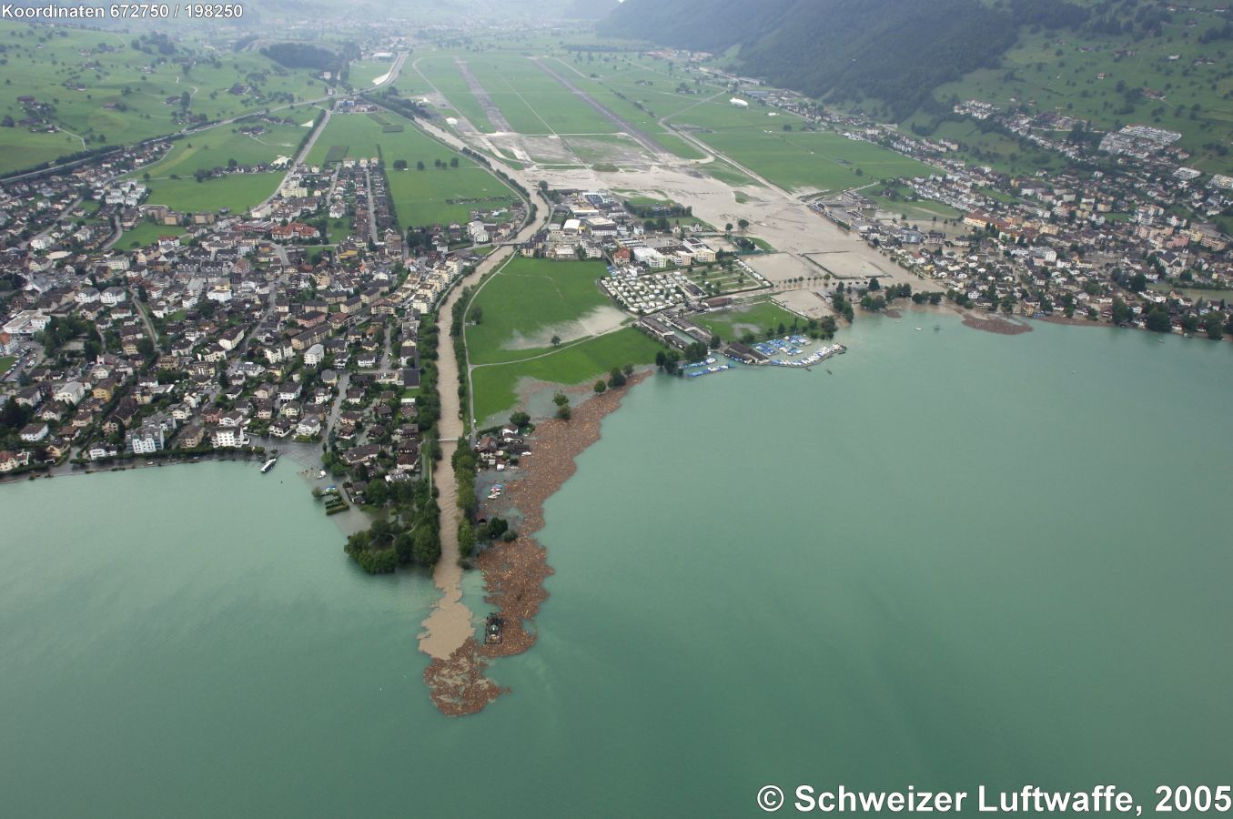 Mündung der Engelberger Aa in den Vierwaldstättersee im Aug. 2005 (Position 2'675'036.72, 1'203'648.21). Blick Rchtg SW. Dorf links im Bild: Buochs; Dorf rechts im Bild: Ennetbürgen mit v.a. überschwemmtem Gebiet 'Riedmatt'. Treibholz im See.
